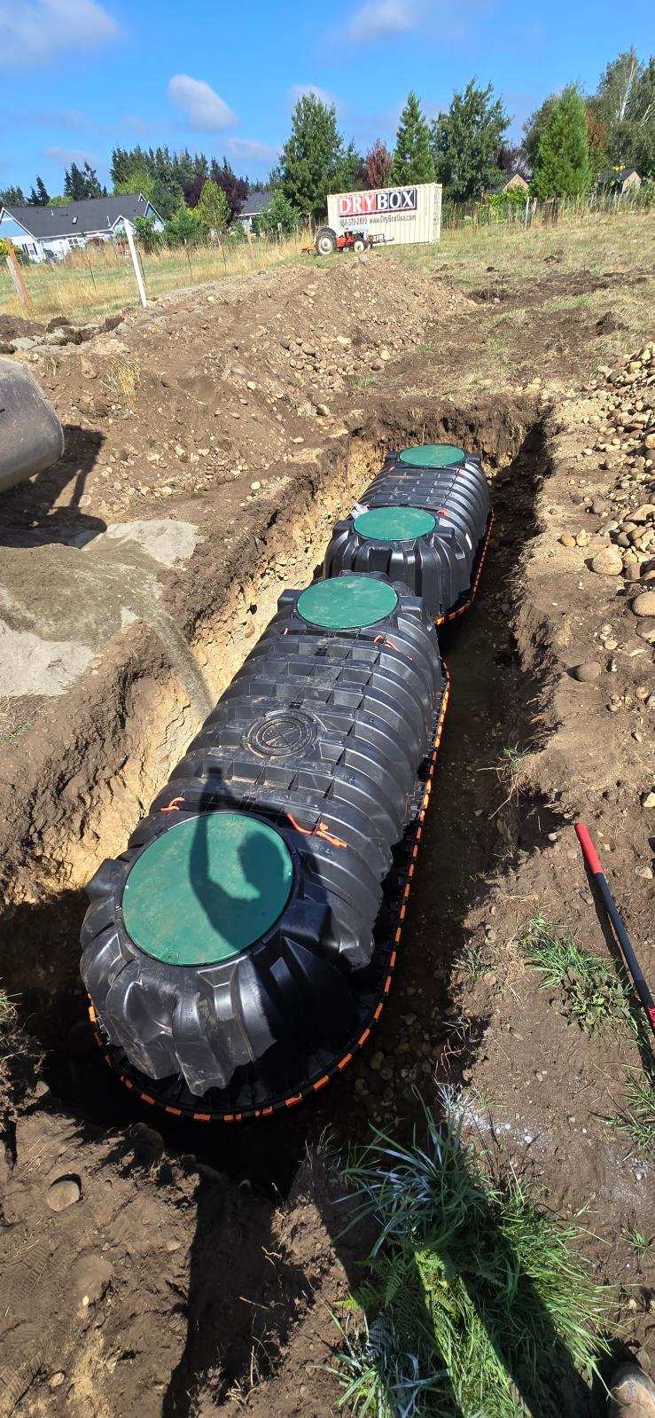Plastic septic tank being installed in excavated trench